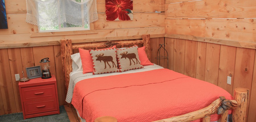 a log bed in a glamping cabin tent