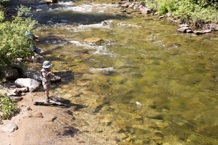 boy catching a trout in idaho wilderness