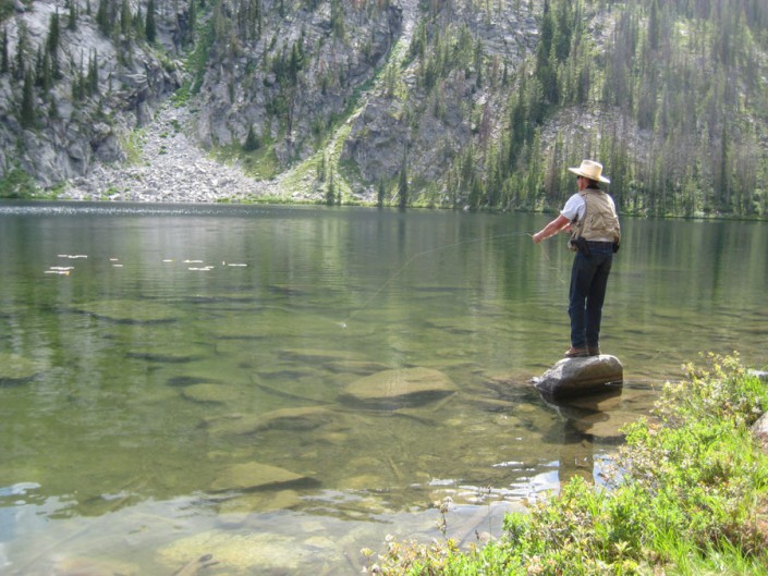 man fishing in a beautiful mountain lake