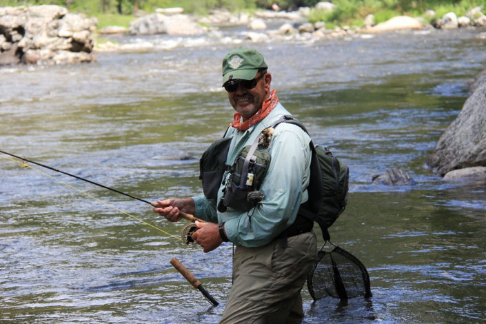 man smiles as he fishes for trout in selway river