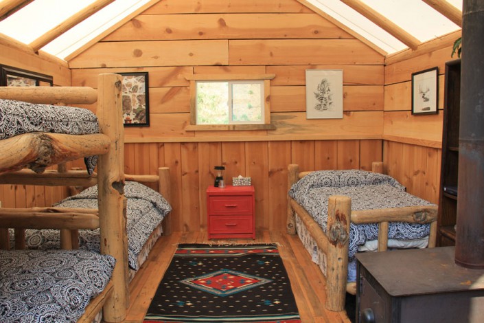 glamping cabin tent with bunks and beds and art